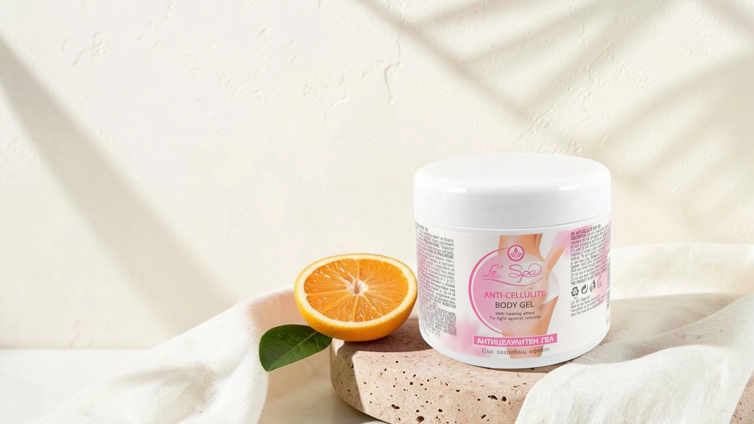 Le’Spa anti-cellulite gel on travertine with an orange and a linen cloth